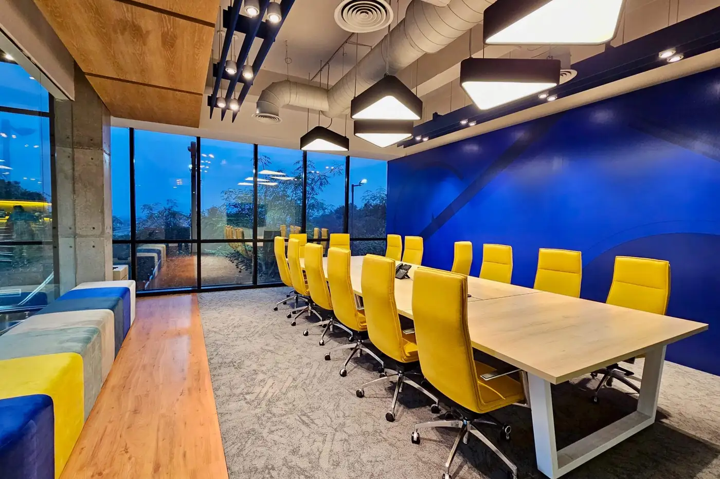 Bright meeting room with a long table and yellow chairs
