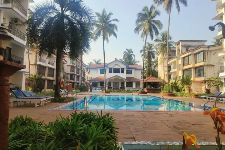 Low-rise residences around a palm-fringed swimming pool