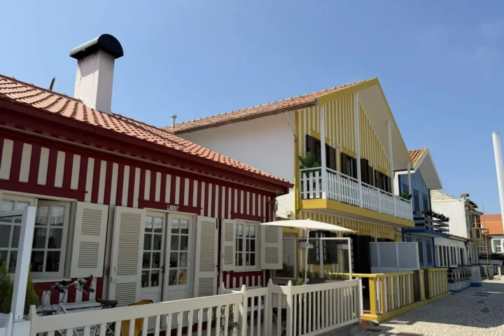Row of striped seaside cottages with white picket fences