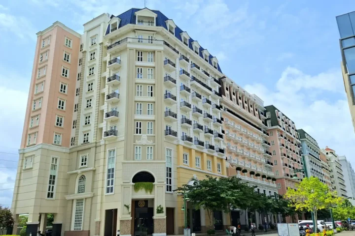 Classic residential tower with arched entrance and street trees