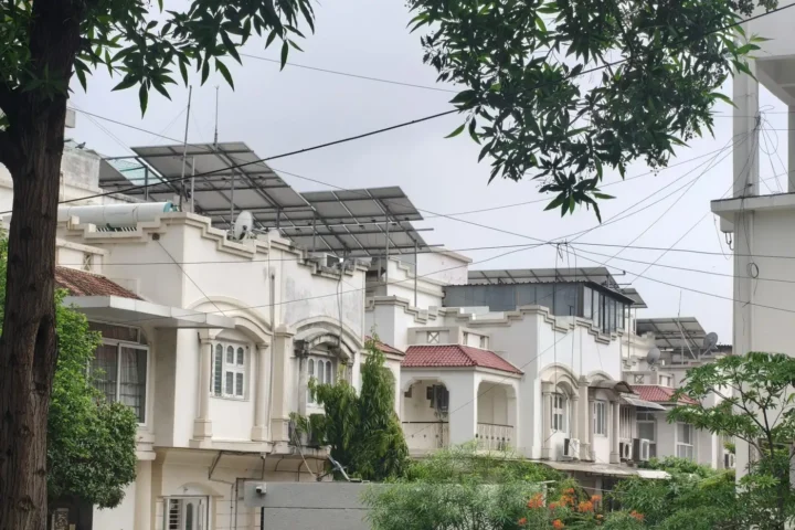 White villa-style homes with balconies among mature trees